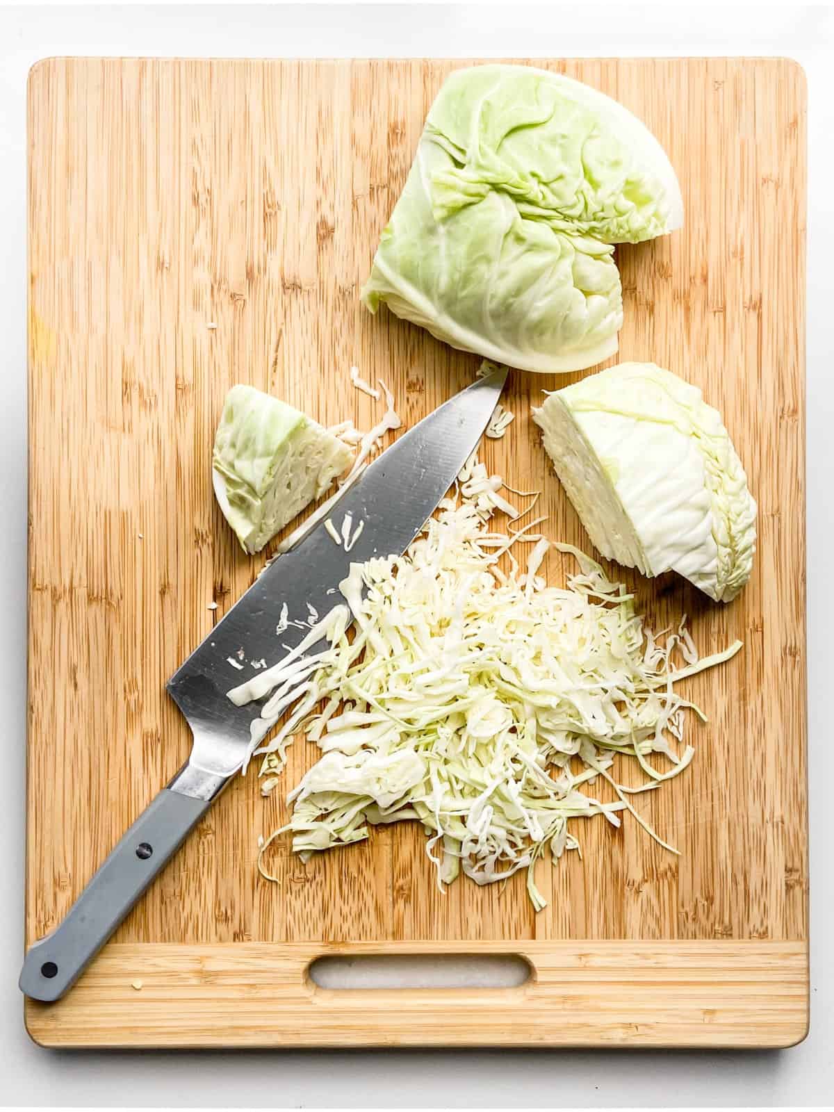 thinly sliced cabbage on a chopping board