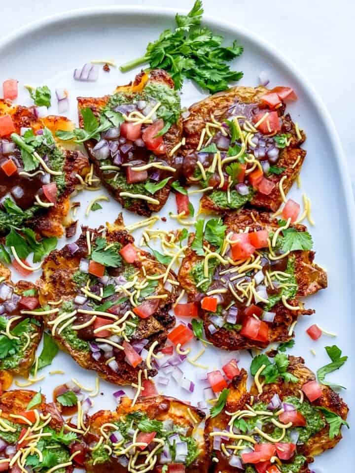 Green, red, and brown food on a white platter