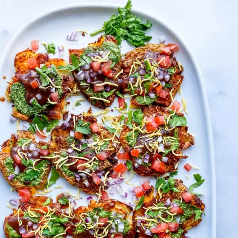 Green, red, and brown food on a white platter