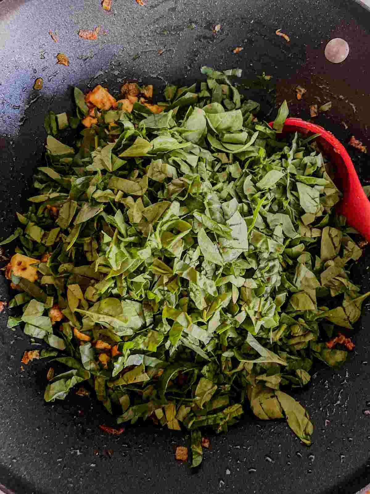 Roughly chopped spinach added to paneer masala