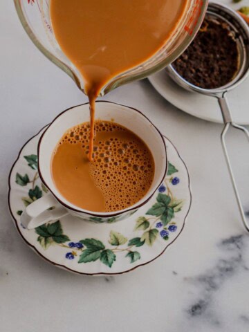 Pouring masala chai in a cup