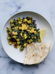 Palak paneer stir fry served with roti and lemon wedge