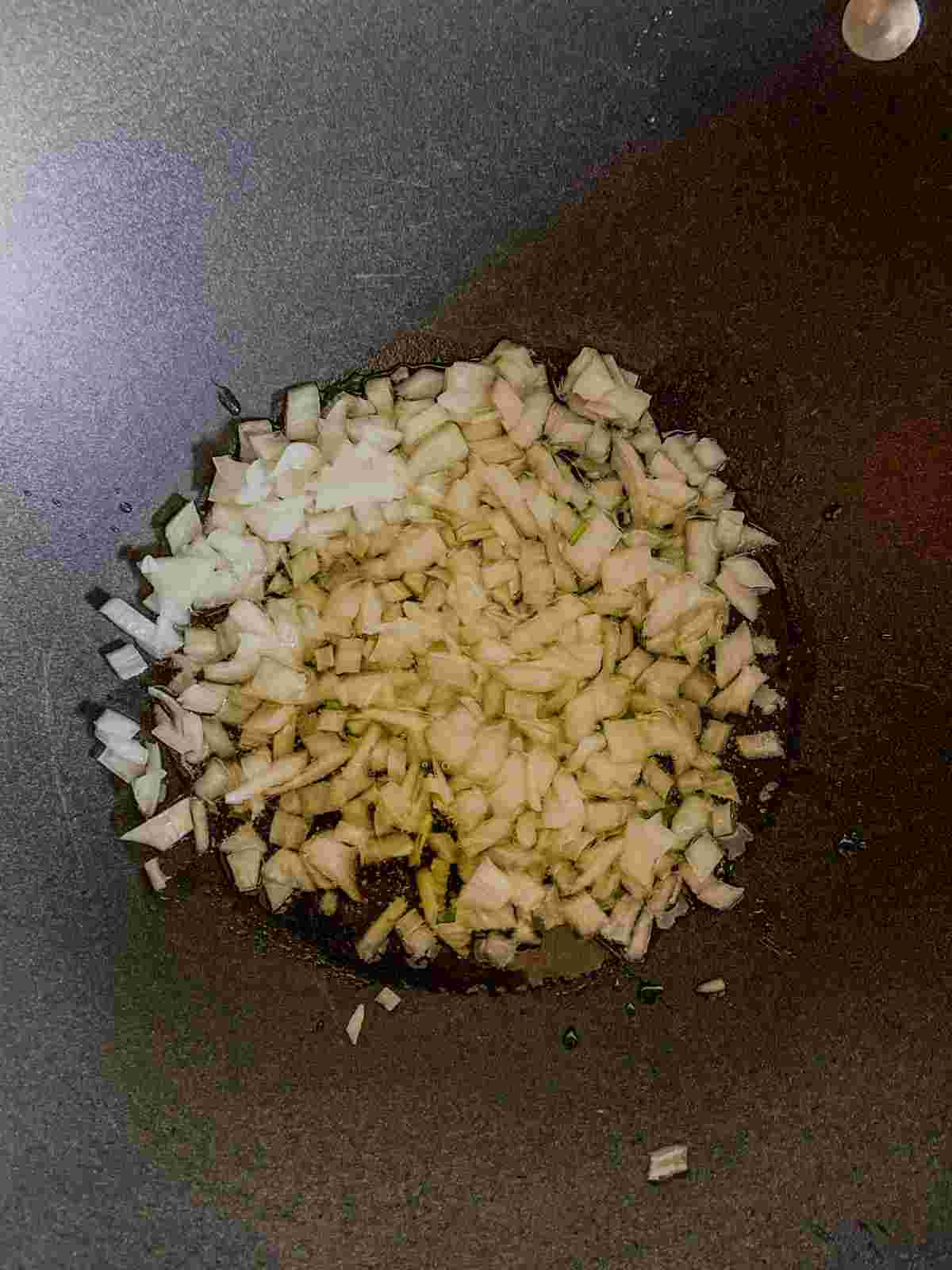 Chopped onion sautéing in oil for palak paneer sabzi