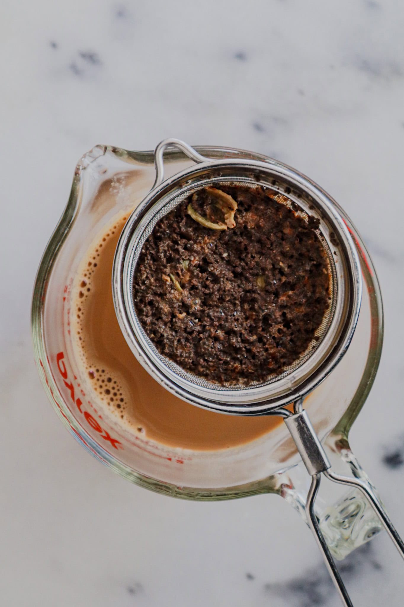 Straining hot Masala Chai into a cup